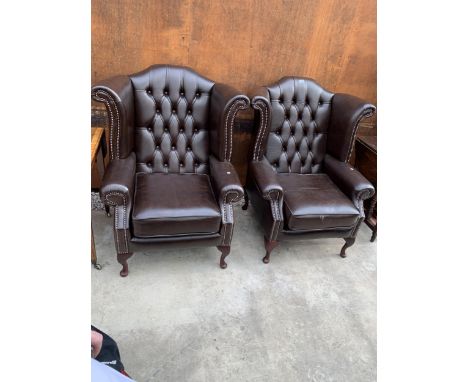 A PAIR OF BROWN LEATHER WINGED BUTTON BACK FIRESIDE CHAIRS ON FRONT CABRIOLE LEGS