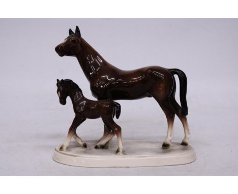 A VINTAGE HERTWIG KATZHUTTE GERMAN PORCELAIN FIGURE OF A BROWN HORSE MARE WITH ITS FOAL IN A GLOSSY FINISH