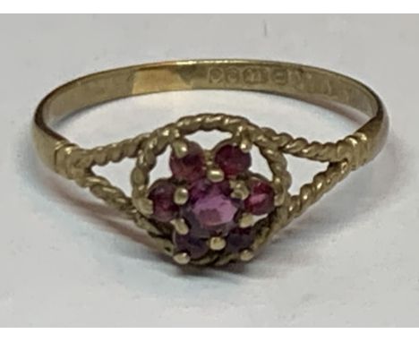 A MARKED 9 CARAT GOLD RING WITH RUBIES IN A FLOWER DESIGN SIZE R