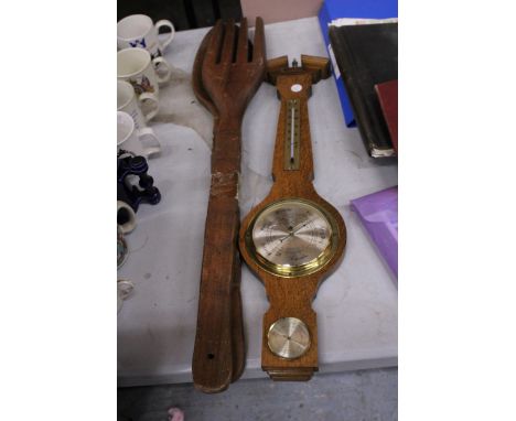 A CLEVEDON BAROMETER AND A LARGE DECORATIVE WOODEN SPOON AND FORK