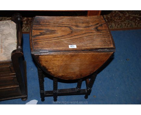 A 1940's Oak drop-leaf gateleg oval topped Occasional Table, on bobbin turned legs and gatelegs.