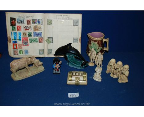 A quantity of miscellanea including carved figures, stamp album, Poole dolphin (as found), etc.