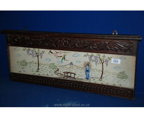 A large carved Oak frame with embroidered panel