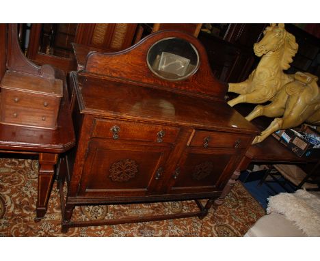 A 1940's Oak mirrorback Sideboard with oval bevel plated mirror in upstand back, the base having two plain drawers over oppos