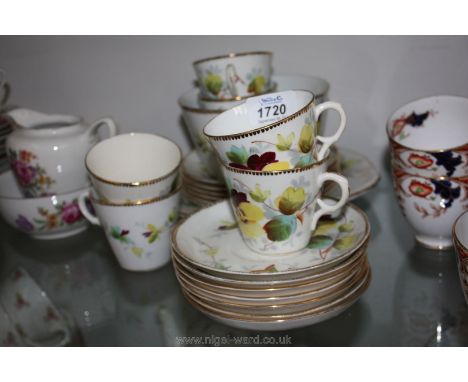 A part Teaset decorated with pansies and gilt edging including six cups and saucers, six plates, cake plate and slop bowl