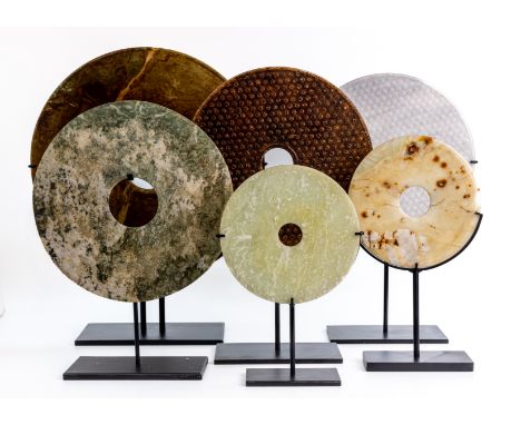 A GROUP OF SIX JADE / STONE DISCS Comprising of various colours and sizes, each mounted on a metal stand The largest disc 40c