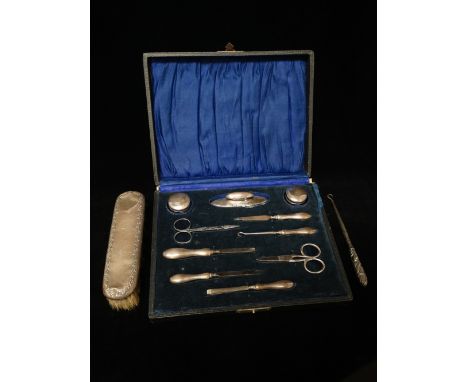 A silver manicure set, Birmingham 1920, associated makers, cased, together with a silver backed clothes brush and a white met
