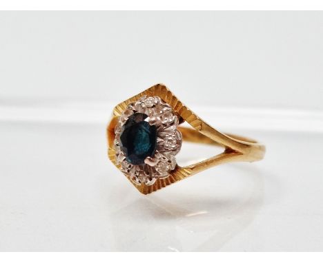 18ct gold diamond and sapphire ring - An 18ct gold ring set an oval sapphire surrounded by eight diamonds, size M/N.