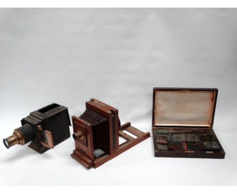 A tin-plate magic lantern with brass-bound lens, slide-carrier and electric illuminant; a selection of hand-coloured lantern 