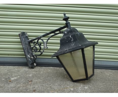 A black painted aluminium wall mounted lantern with four glazed panels, height 63cm, width 31cm, depth 72cm. 