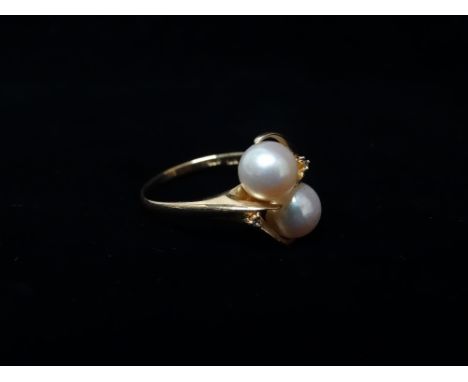 14ct gold and pearl ring - A 14ct gold crossover ring set two pearls and two diamond chips, size N/O.