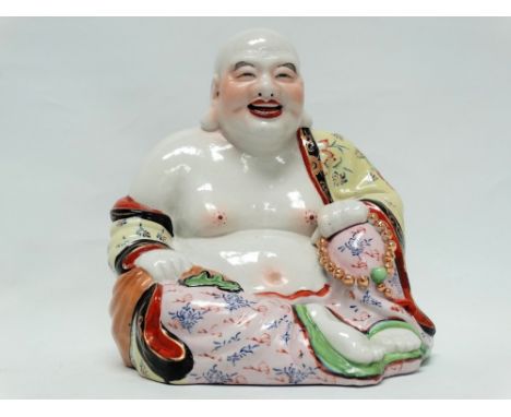 Chinese 20th century ceramic Buddha - A polychrome decorated Buddha sat holding a bead and jade necklace in one hand and a sa