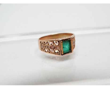 Emerald ring - An 18ct gold ring set an emerald cut emerald and a two line row of diamond chips to the filigree shoulders, si