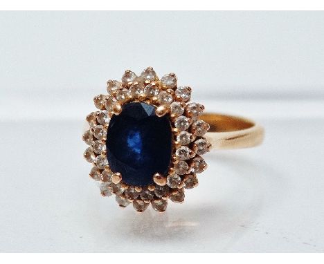 Sapphire and diamond ring - A high carat gold ring set a faceted sapphire, length 8mm surrounded by two rows of diamonds.