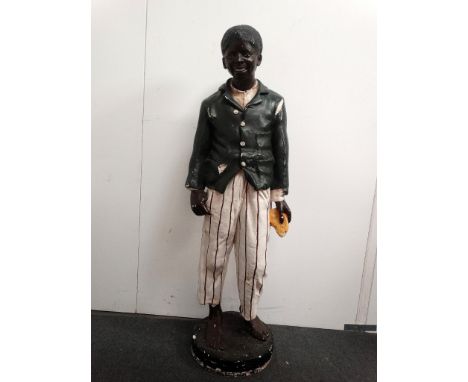 Shop Display Figure - A polychrome plaster life size figure of an African American boy with a light red/orange painted jacket