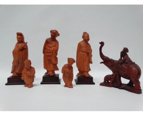 Oriental hardwood carvings - A boxwood group of three larger female figures on squared hardwood socles, two children, a girl 