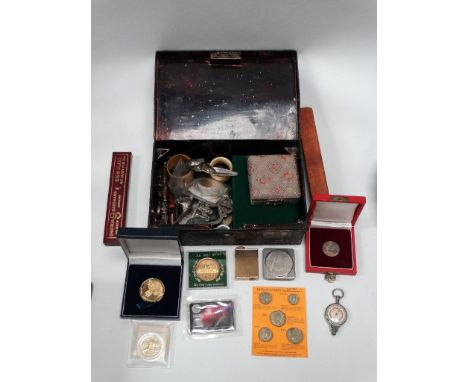 A tin containing tokens, coins, napkin rings, a lighter, penknife and other miscellaneous items. 