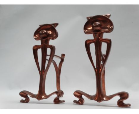 Art Nouveau - A pair of cast copper fire dogs of tendril, sphere and stylised arch shape, height 26cm. 