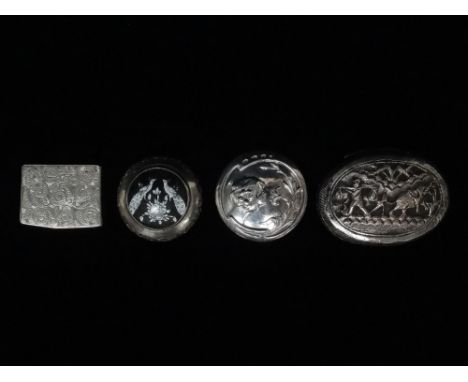 A white metal pill box, the lid decorated with an elephant, palm trees and a man carrying a pannier, height 1.7cm, width 5.8c