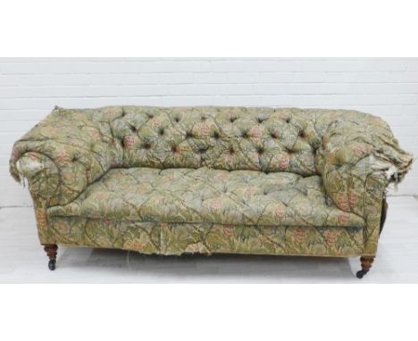 19th century Chesterfield sofa, with worn Morris style floral upholstery, on mahogany legs with brass caps and castors, 74 x 