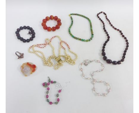 A collection of coloured hardstone jewellery to include beads and a bracelet together with a white metal ring and a Buddha ca