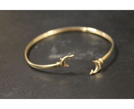 A YELLOW METAL BANGLE WITH DOLPHIN DETAIL, STAMPED 9 TO ONE COLLAR, APPROX WEIGHT 2.8G