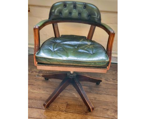 A captain's chair with green leather button back and seat, green leather on arms, stud finish to leather, swivel chair on cas