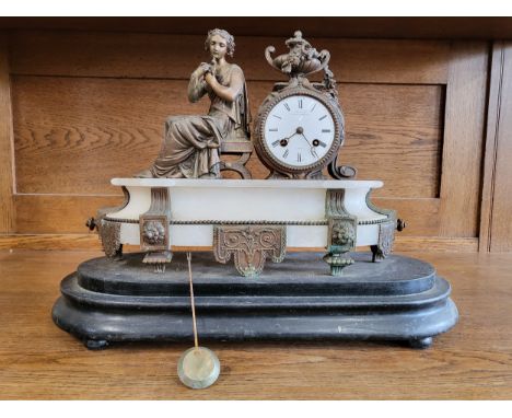 An ornate mantle clock, the white dial beside the seated figure of a Classical woman, raised on white onyx stand, with black 