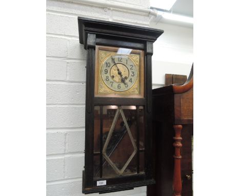 A 1920's dark oak cased wall clock having Art Nouveau decoration to face