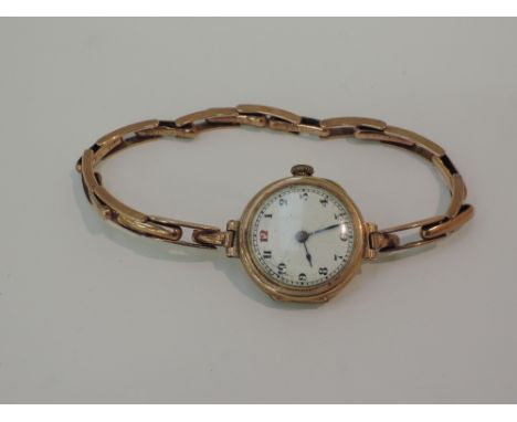 An early 20th century ladies 9ct gold wrist watch having Arabic numerals to white enamel dial on a 9ct gold stretch strap