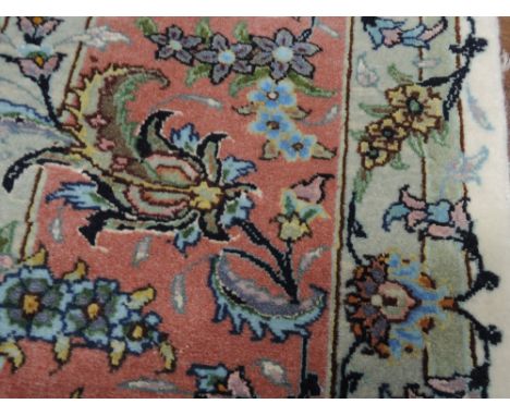 A silk carpet square of Persian design having foliate decoration on cream ground
