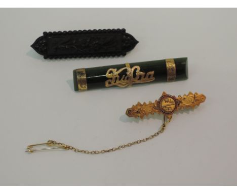 A yellow metal bar brooch stamped 15ct having wire work decoration, a mourning brooch having floral decoration and a jade sty