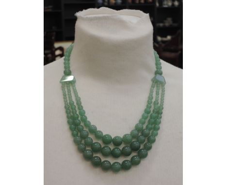 A jade bead necklace having a graduated three strand section to front