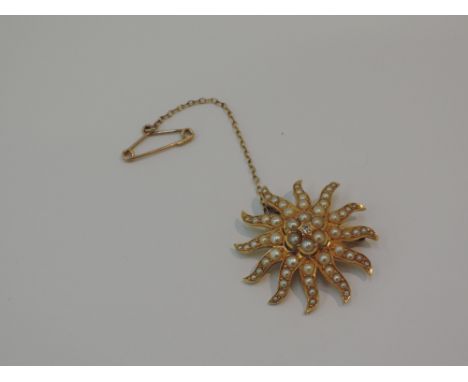 A yellow metal star burst brooch/pendant stamped 18ct having seed pearl and diamond decoration,  approx 5.5g