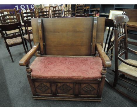 A mid 20th century oak monk's bench of traditional design having carved lozenge panel decoration