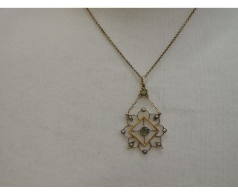 An Edwardian yellow metal pendant stamped 9ct having central peridot within an open square mount with further seed pearl deco
