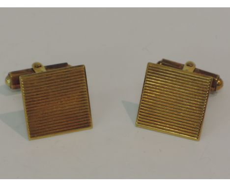 A cased pair of 9ct gold cufflinks of square form with ridge decoration, retailed by Alfred Dunhill Ltd, London,  in their or