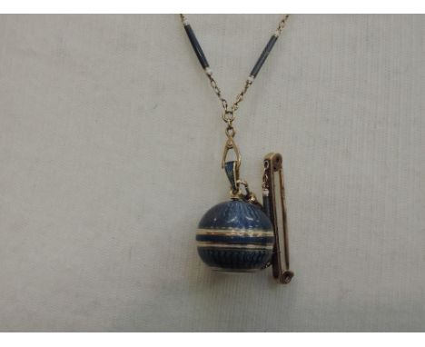 A yellow metal and navy guilloche enamel pendant watch of spherical form having Arabic numeral dial, and enamelled inserts to