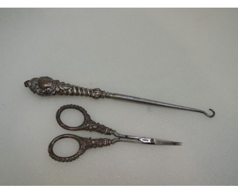 An HM silver handled button hook and pair of manicure scissors having moulded decoration