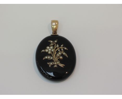 A Victorian black jet mourning pendant having seed pearl floral decoration to front and locket to reverse