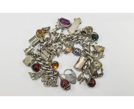 A Solid Silver and Heavy Curb Bracelet - Loaded with Over 33 Good Quality Vintage Charms. All Fully Marked for Silver, Some S