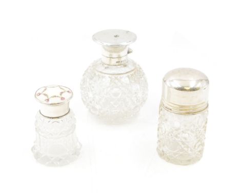 Three cut glass silver scent bottles/jars with silver lids, comprising one example with painted floral enamel cover, hallmark