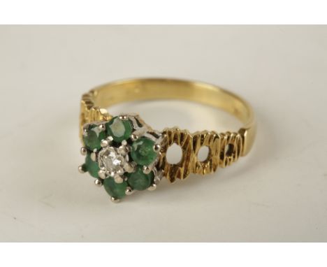 EMERALD AND DIAMOND CLUSTER RING, the centre diamond approx .05ct surrounded by a boarder of six emeralds, on an 18ct yellow 