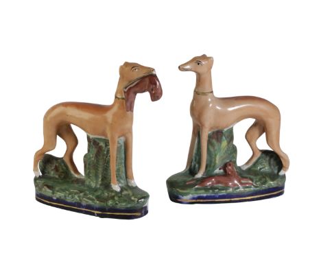 PAIR OF STAFFORDSHIRE POTTERY GREYHOUNDS painted in enamel colours on green moulded and blue gilt-lined oval bases, 24cm