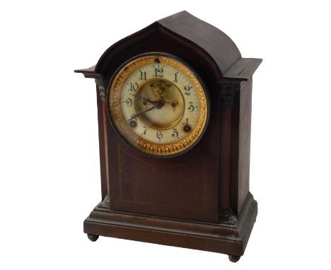 An Edwardian mahogany and marquetry mantel clock, with arched top, French enamel dial and movement, on bun feet, 30cm high. 
