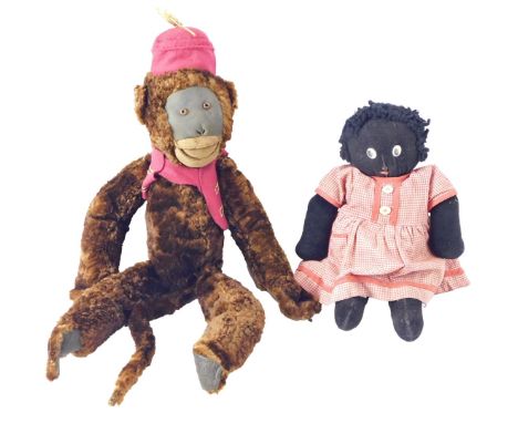 A vintage brown plush monkey, wearing a fez with waistcoat, 42cm long, and a female golly doll. (2)