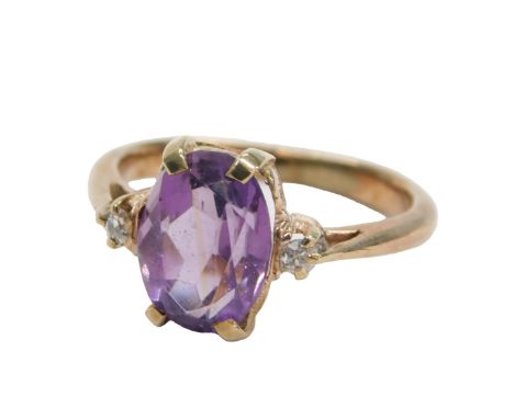 An amethyst ring, oval cut in a claw setting, with diamond set shoulders, in rose metal, unmarked, size K½, 3.2g. 