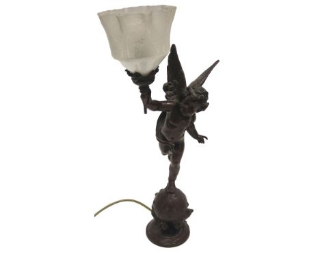 A bronzed spelter lamp base, modelled in the form of a putti holding a torch with associated etched shade, 54cm high. 