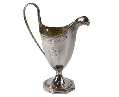A George III silver faceted helmet shaped cream jug, engraved with a crest within a band of leaves, etc., on an octagonal bas