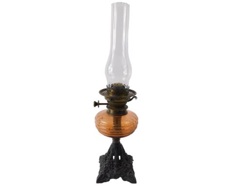 A Victorian oil lamp, with red tinted glass reservoir, and tapering ebonised cast iron base, 53cm high to top of fitting.